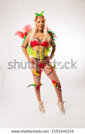 Tall blonde black woman in Carnaval costume and athletic shoes posing on clean white background