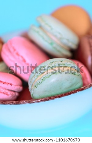 Cake macaron or macaroon on turquoise background, pastel colors, tasty food card