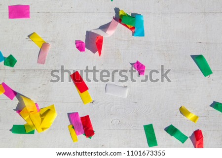 multicolored confetti on the white painted wooden floor or table background