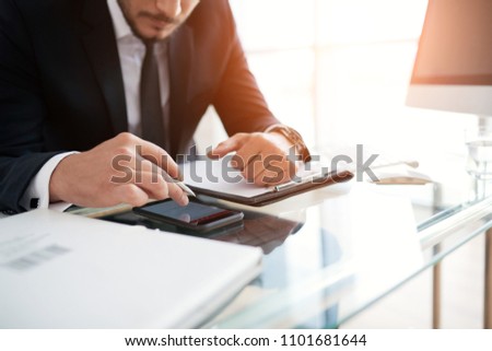 Cropped image of businessman reading article on his smartphone