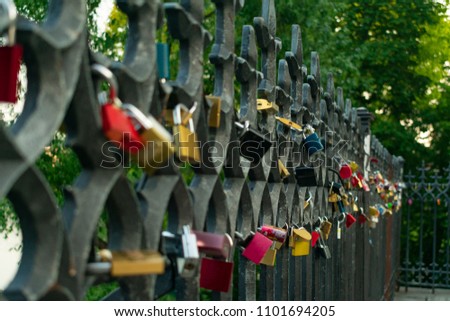 locks of lovers on the iron fence near the river on the bridge, as a symbol of marriage ties