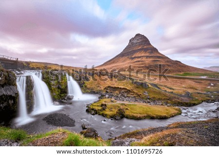 Summer sunset over the famous Kirkjufellsfoss Waterfall with Kirkjufell mountain in the background in Iceland. Long exposure HDR. Vacation May 2018.