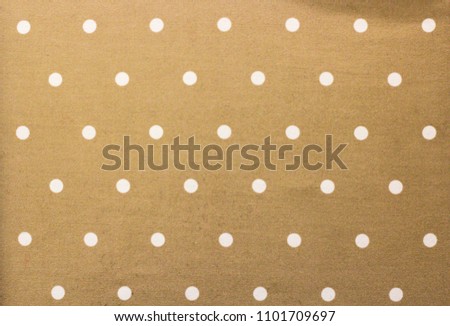Golden fabric and a white tiny polka dots background