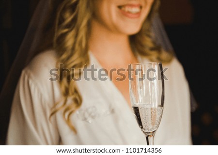 A glass of champagne in the hand of the bride.  Bride hand holds a glass of champagne. 