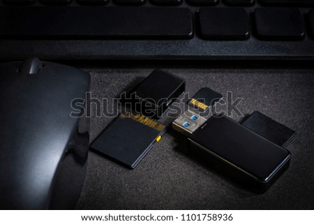 USB flash drive and memory card above computer. place on Office desk / selective focus
