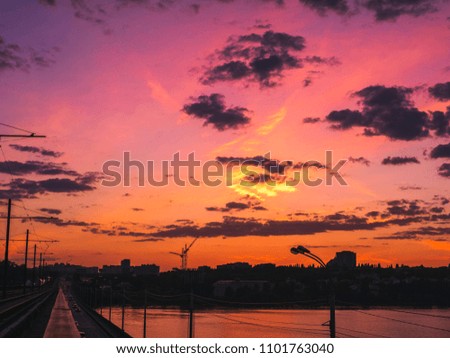 Dramatic sunset and silhouettes of city buildings in summer evening.