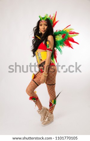 Skinny young dark haired hispanic woman in Carnaval costume and athletic shoes posing on clean white background