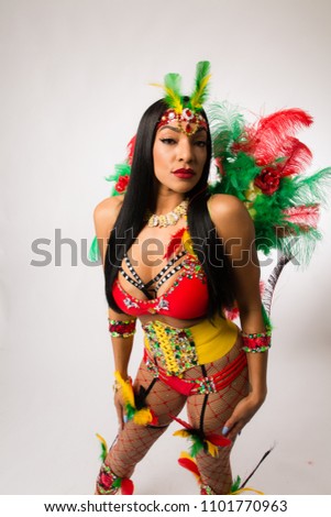 Fit young dark haired mixed race woman in Carnaval costume and athletic shoes posing on clean white background