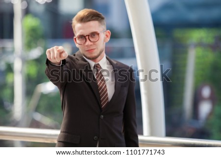 Confident businessman. Confident young man in full suit tump up while standing outdoors