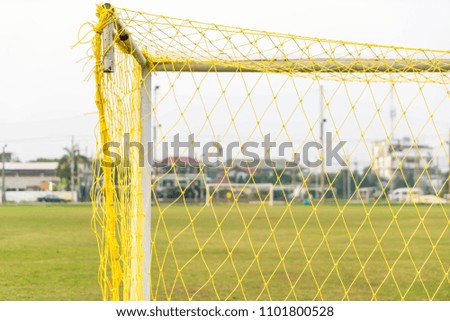 A soccer goal on green empty football field