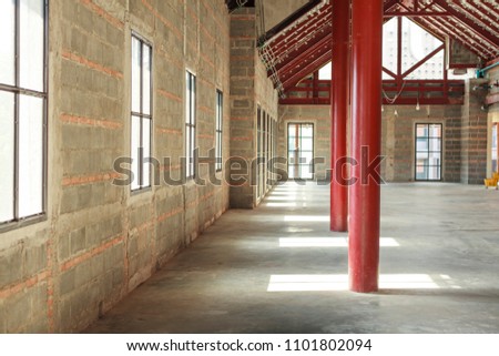 Indoor building The sun shines through the window into the room. Red pillars in the middle of the room