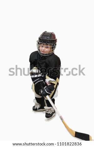 Isolated cute little kid hockey player in full hockey equipment. Helmet, gloves, stick.