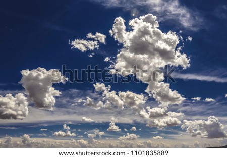 Light cumulus clouds in the blue sky. Wide photo.
