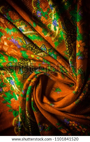 Texture, background, pattern. Mustard color with rose flowers fabric, headscarf. With a sewn silver thread. Indian motifs.