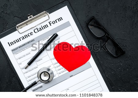Health insurance claim form for fill out. Empty form near heart sign and stethoscope on black background top view