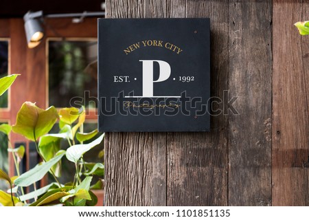 Black signage on a rustic wooden wall mockup Royalty-Free Stock Photo #1101851135