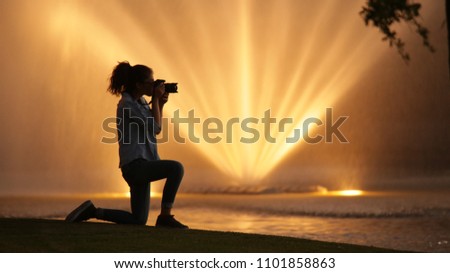 Girl taking pictures in extraordinary landscape full of light and water