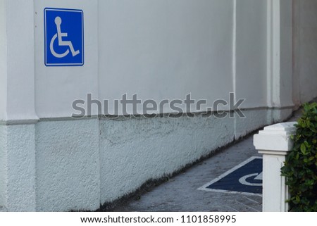 Ramp for wheelchair of disabled with a symbol on wall.
