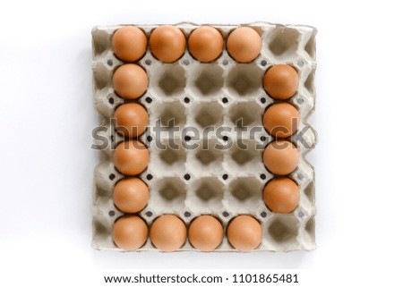 Alphabet letters arrange from eggs in paper tray on white background.