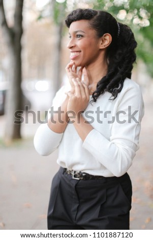 Beautiful black woman wearing white blouse and black pants. Concept of beauty and business person.