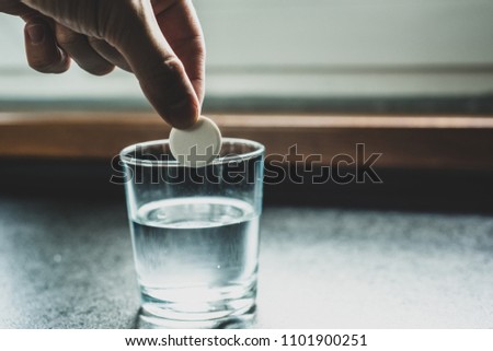 The man holds a tablet in his hand, dissolves it in water. Concept of medicine and health. Taking drugs, dependence on medicines. Help for pains.
