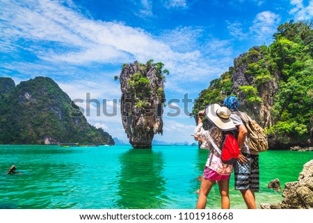Asian couple traveler with packpack relaxing on amazing nature sea beach joy view James Bond island, Phuket, travel Thailand, Beautiful destination landscape Asia, Summer holiday outdoor vacation trip Royalty-Free Stock Photo #1101918668