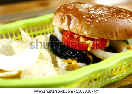 Photo of cheeseburger and potato chips