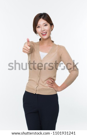 Young Asian woman showing thumb isolated on white.