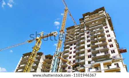 Two self-erection cranes near building. Scaffolding. Construction site background.