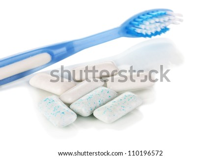 Chewing gum and toothbrush close-up isolated on white