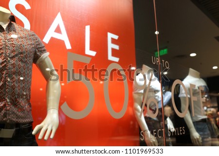 Special sale up to 50% off text on a glass wall obstruct a view inside the popular clothing store