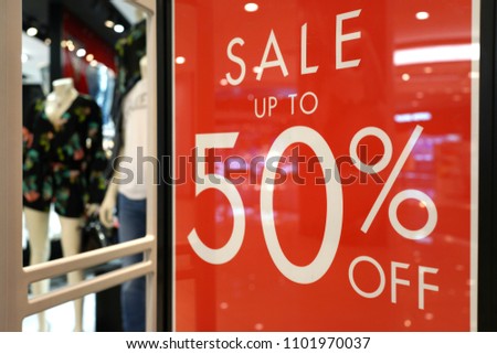 Special sale up to 50% off text on a glass wall obstruct a view inside the popular clothing store