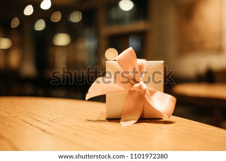 celebration background gift box place on wood table in restaurant with copy space. image for present, birthday, christmas, object, decoration, nobody, holiday concept