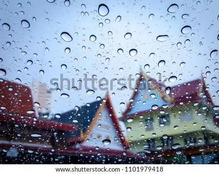 Raindrop on windshield and thai temple style is background