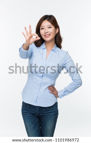 Young Asian woman showing okay sign isolated on white.