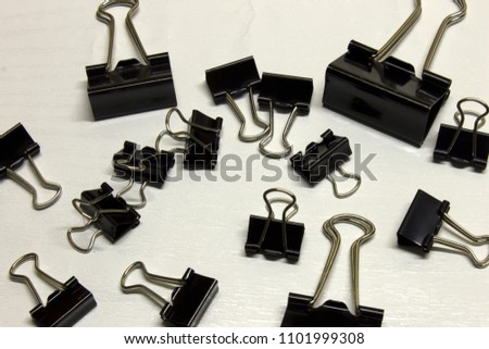 Black Binder clips isolated on a textured White background