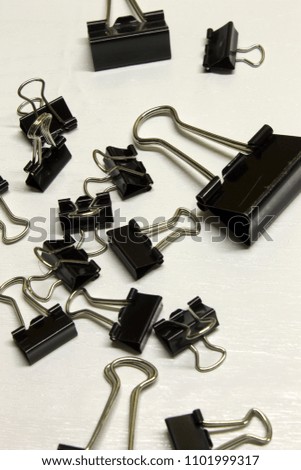 Black Binder clips isolated on a textured White background