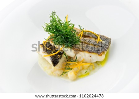 Isolated Plate with slices of sea bass fillets on mashed vegetables