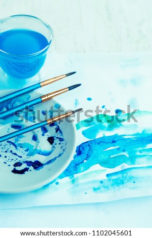 art brushes and blue watercolor paint pattern on paper. drawing, art creativity, artist inspiration concept.