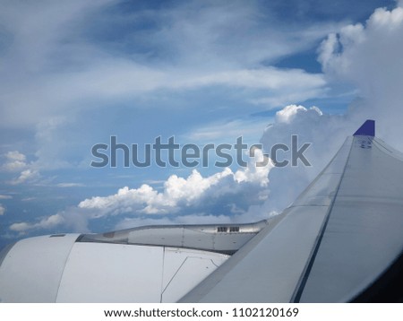 View on the sky from flying airplane with cloud and wing of airplane in picture
