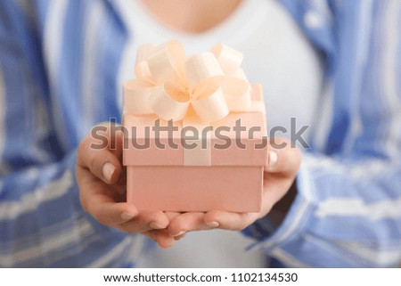 Beautiful young woman with gift box, closeup