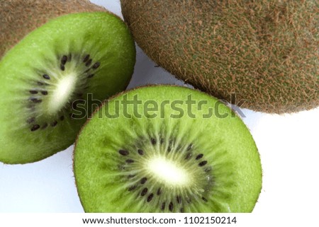 Green Kiwi cut in half next to whole one isolated on white background