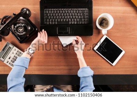 top view, business woman hiding an envelope with a bribe under laptop
