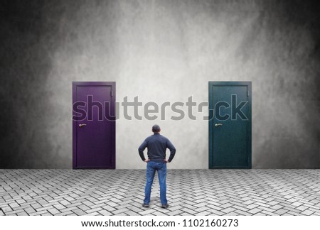 Man does not know which of the two doors he should enter Royalty-Free Stock Photo #1102160273