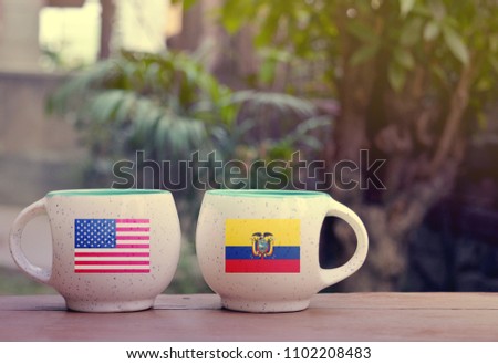 United State of America and Ecuador Flag on two tea cups with blurry background