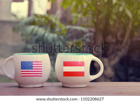 United State of America and Austria Flag on two tea cups with blurry background