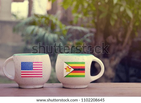 United State of America and Zimbabwe Flag on two tea cups with blurry background