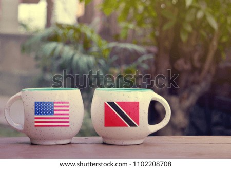 United State of America and Trinidad and Tobago Flag on two tea cups with blurry background