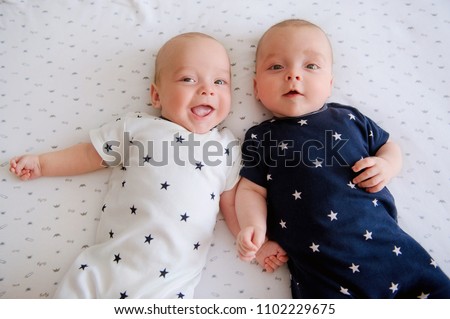 Two adorable twin babies smiling happily. Positive lifestyle concept. Happy childhood. View from above Royalty-Free Stock Photo #1102229675