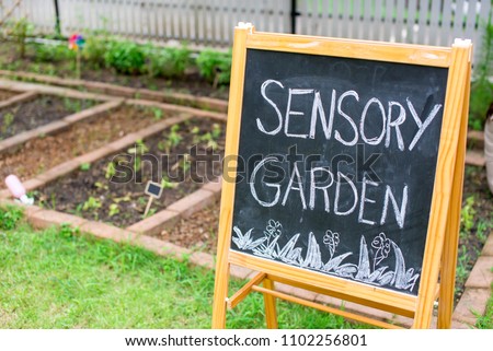 Chalk board next to the garden bed Royalty-Free Stock Photo #1102256801